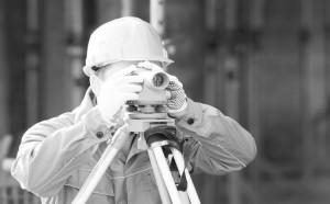 Vermessungstechniker mit Bauhelm und Messger&auml;t